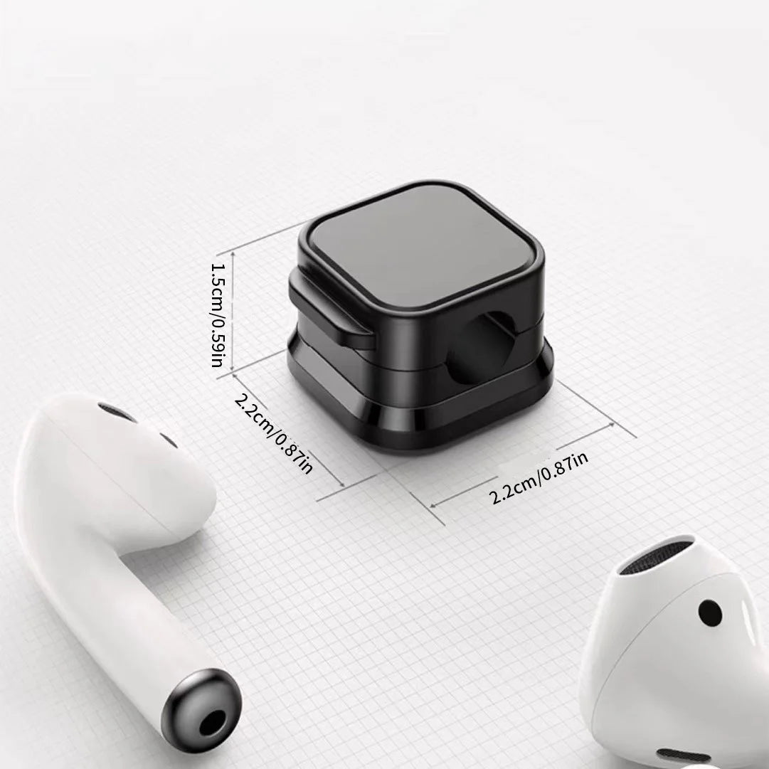 A set of magnetic cable clips shown with a white earbud, demonstrating the size and function.