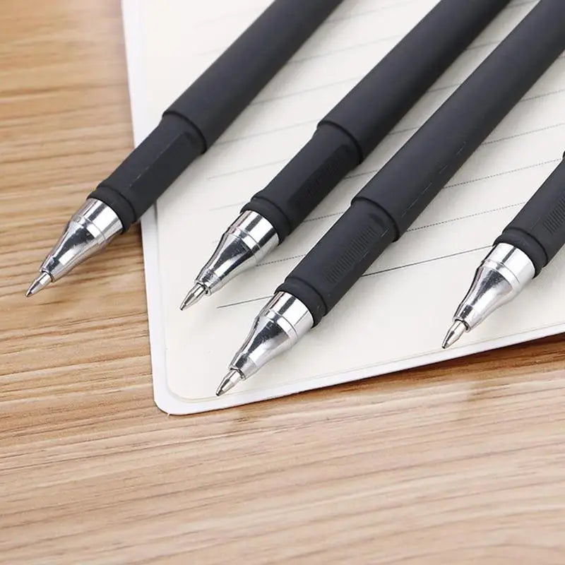 A close-up view of a bulk pack of black gel ink pens lying on a white lined notepad.