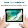 Hands apply a clear tempered glass screen protector to an iPad screen.