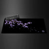 Black gaming mouse pad featuring a delicate purple cherry blossom branch design.