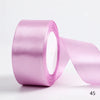 A roll of light pink satin ribbon used for gift wrapping and DIY crafts.