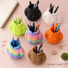 A collection of colorful puffer jacket pen holders in various shades like green, orange, and pink, arranged on a light backgr