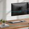 Hands adjust a heavy duty dual monitor desk mount system for an effortless setup and clean look.