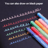 A collection of colorful acrylic gel pens drawing wavy lines on black paper.