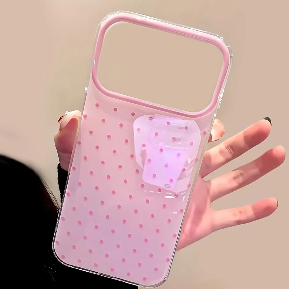 A clear pink phone case with small pink polka dots and a rounded handle is held in a hand.
