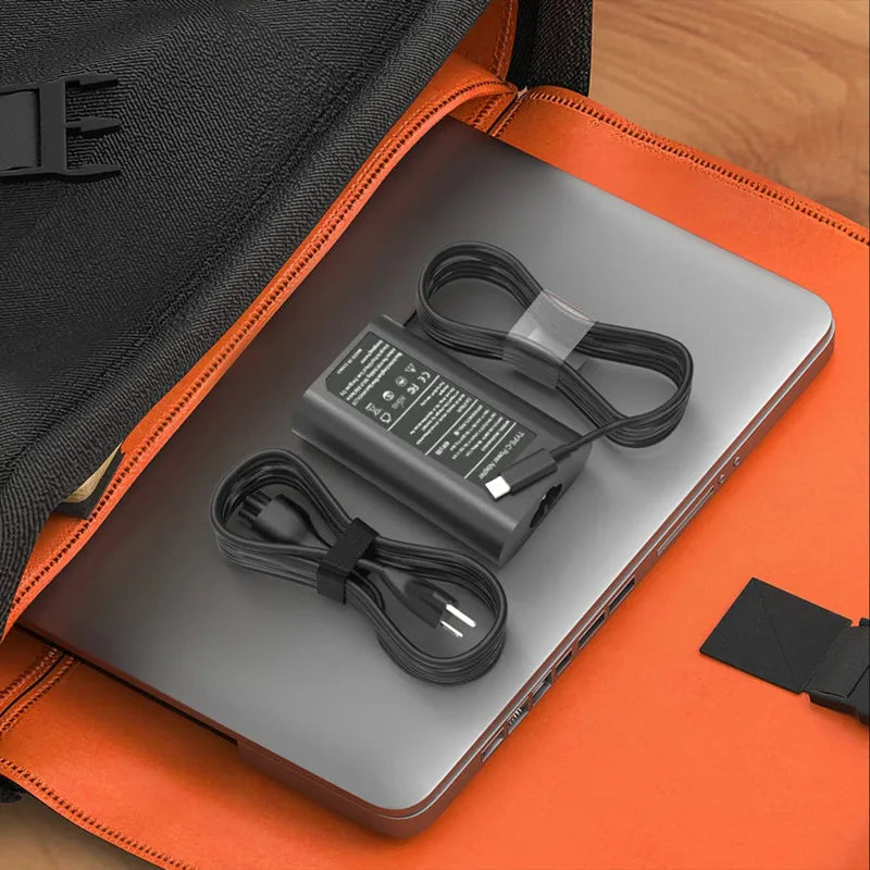 Una laptop con un adaptador de corriente USB Tipo-C negro dentro de una funda protectora naranja.