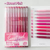 A set of nine pink gel pens in various shades and tips displayed next to a sheet of paper with matching colored pens.