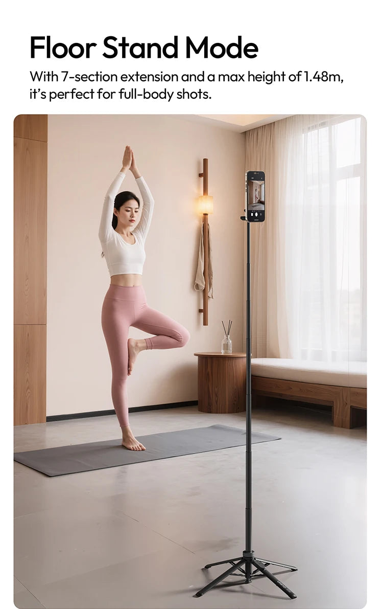 A woman performing a yoga pose using a floor stand mode tripod for a phone.