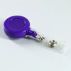 Porta credencial de plástico morado con clip plateado en una funda de tarjeta de plástico transparente.