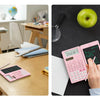 A pink scientific calculator with a built-in notepad is shown being used on a wooden desk.