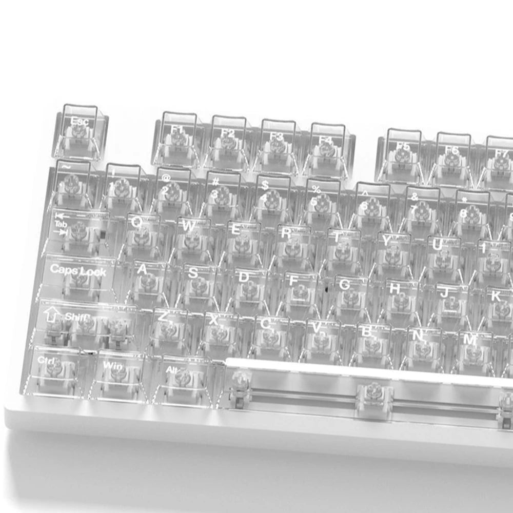A close-up view of a clear and frosted mechanical keyboard featuring alphabet keycaps arranged in a grid.