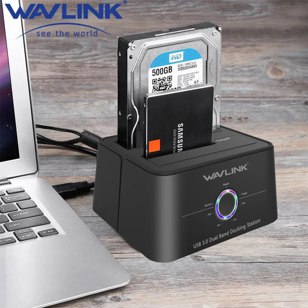 A black WAVLINK USB 3.0 Dual Bay Docking Station with an SD card and a 500GB SSD inserted, next to a laptop.