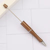 A set of brown beadable pens with silver accents resting on a white tiled surface.