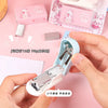 A hand holds a light blue cartoon mini stapler, demonstrating its use for stapling paper.