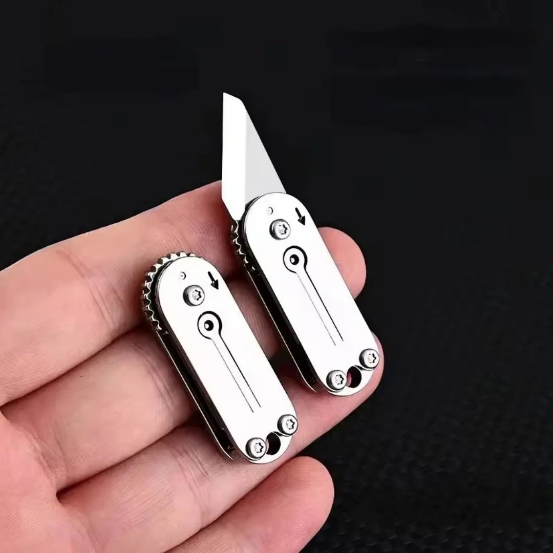 A stainless steel pocket knife with a blade and handle is held in a hand against a dark background.