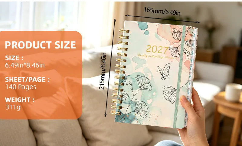 A spiral bound planner with monthly tabs showing a floral watercolor design and dimensions.