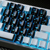 Nahaufnahme einer mechanischen Tastatur mit personalisierten Schmetterlings-Keycaps und blauem LED-Licht.