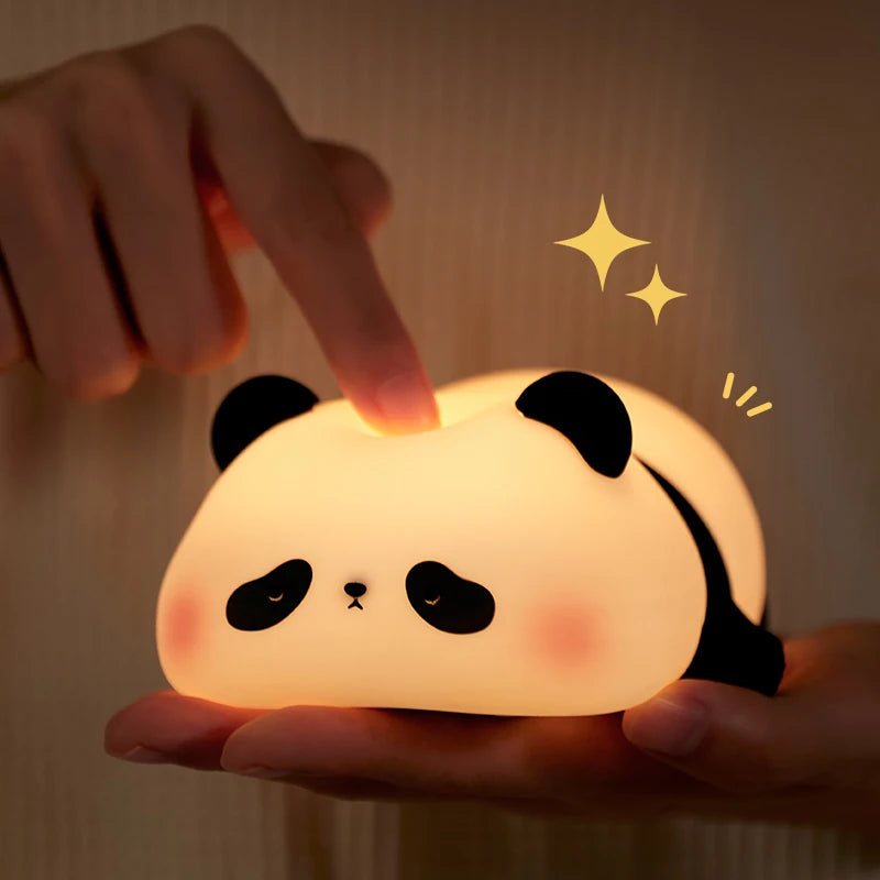 A hand holds a glowing white panda silicone night light with touch control and stars, illuminating the face.