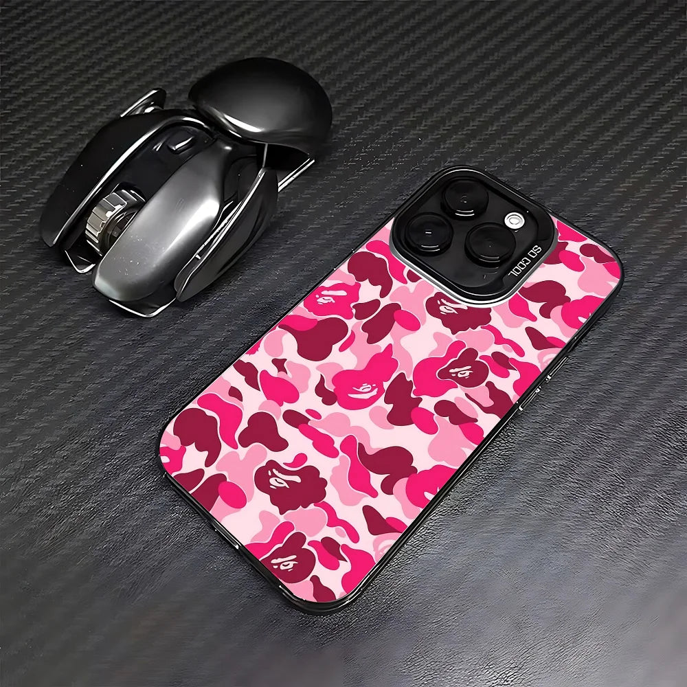 A black Apple AirPods case and a pink camouflage patterned iPhone case are displayed on a dark surface.