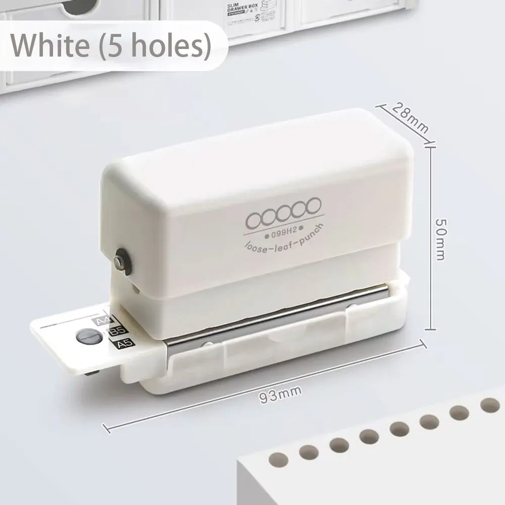 A white mini multi-hole punch tool with five holes is shown next to a stack of paper.