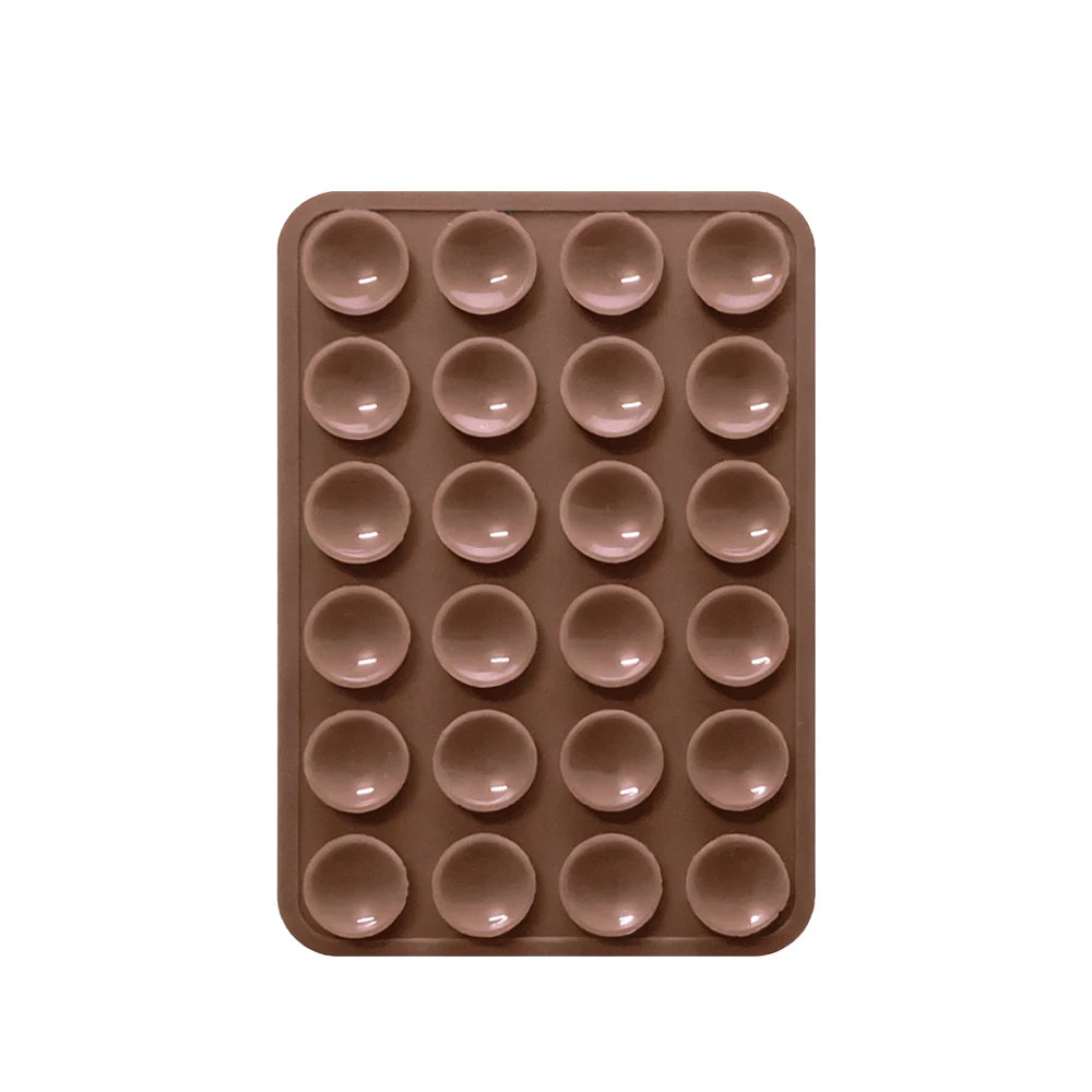 A brown silicone suction phone mount with multiple circular holes for mounting devices.