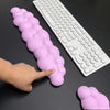 Une main touche un repose-poignet clavier rose et moelleux, à côté d'un clavier blanc et d'un autre repose-poignet rose.