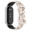 A beige silicone watch band with engraved flowers and a black smart band housing.