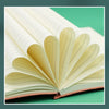 An open premium A5 leather journal showing cream-colored lined pages and a reddish-brown cover.