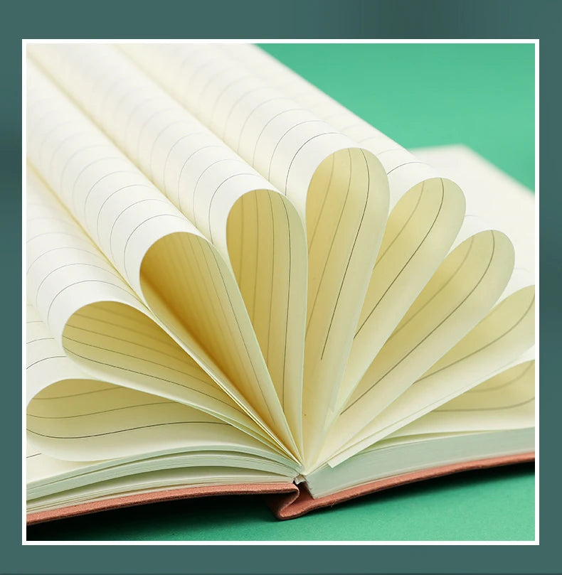 An open premium A5 leather journal showing cream-colored lined pages and a reddish-brown cover.