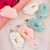 A collection of pink and mint green adorable cat paw mini cutters for mail and crafts displayed on white fabric.