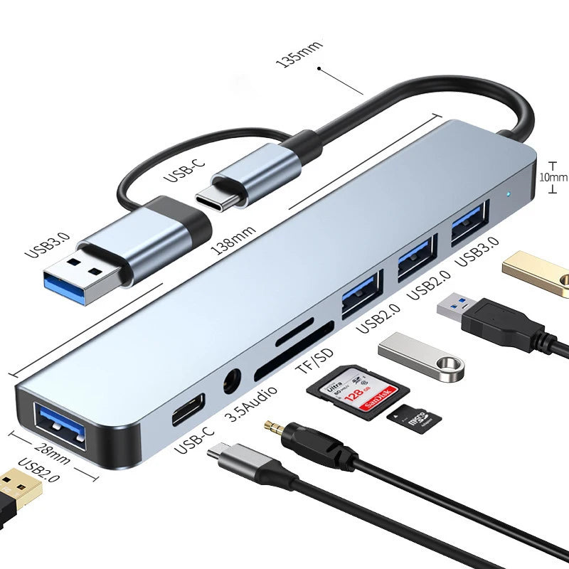 A silver multi-port USB-C hub adapter featuring multiple USB ports, an audio jack, and a detachable cable.