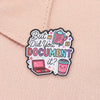 An enamel pin featuring text 'But Did You Document It?' surrounded by icons of a laptop and a drink on a pink fabric backgrou