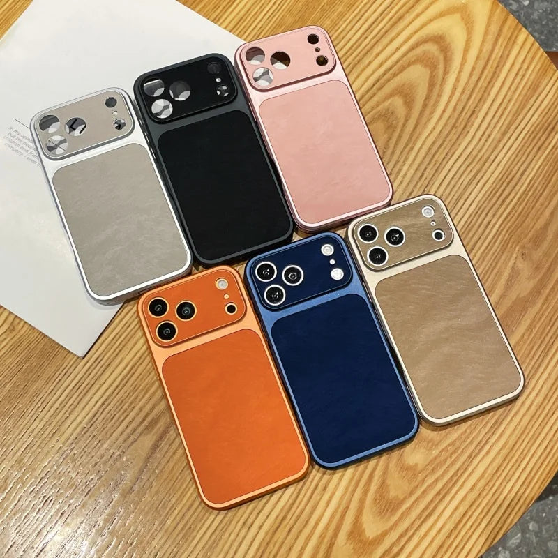 A collection of various colored phone cases, including pink, black, silver, and orange, resting on a wooden surface.