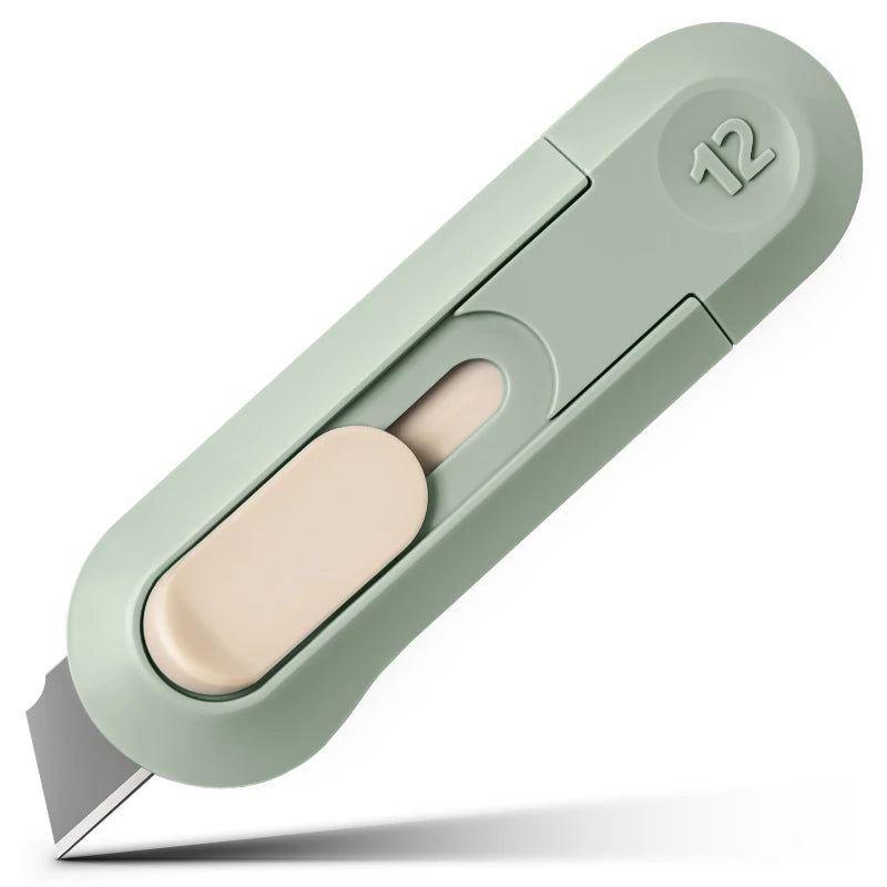 A light green compact mini paper cutter with a beige blade and a numbered box opener feature.