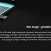 A black USB metal plug is shown next to a laptop keyboard, highlighting its mini design and durability.