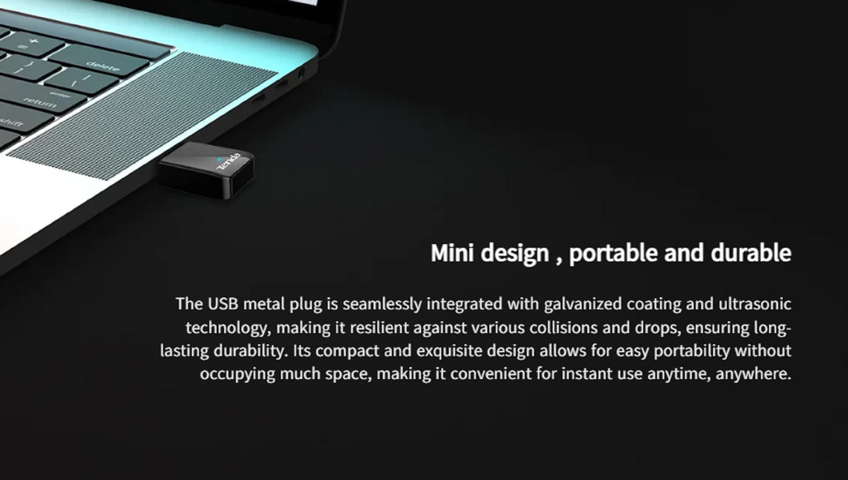 A black USB metal plug is shown next to a laptop keyboard, highlighting its mini design and durability.
