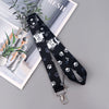 Black lanyard with a cartoon cat design and paw print pattern displayed on a white background.