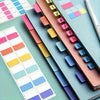 A close-up of colorful index tags and color swatches arranged in a grid on a light green surface.