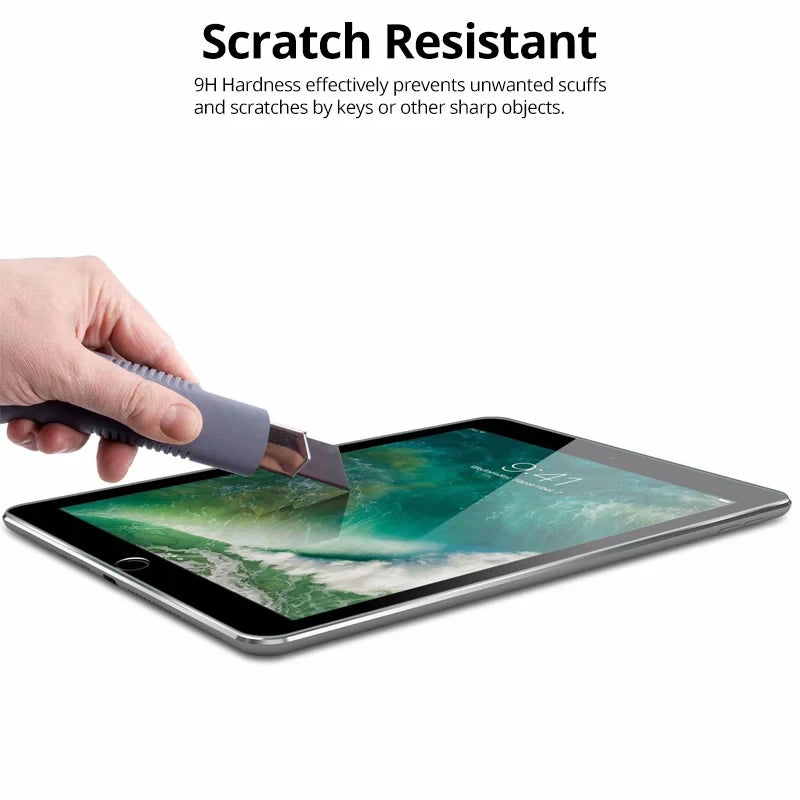 A hand is using a knife to scratch resistant tempered glass screen protector on an iPad display.