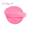 Pink bristleglass elastic hair ties and trims rolled into a flat, circular shape