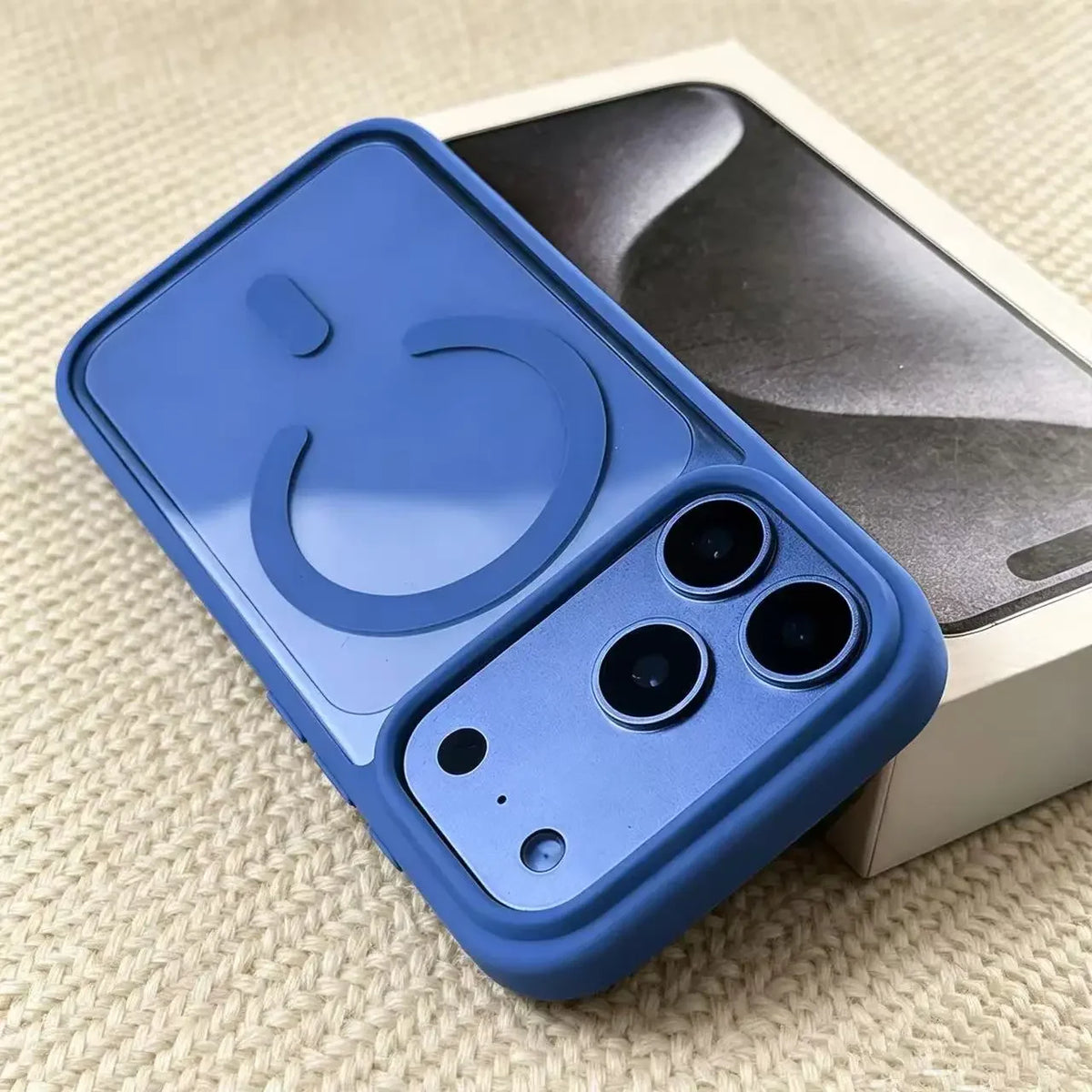 A blue transparent acrylic phone case with a circular cutout and three camera cutouts is shown next to its packaging.