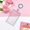 Clear acrylic card holder with a blue keychain attached, displayed on a pink background.