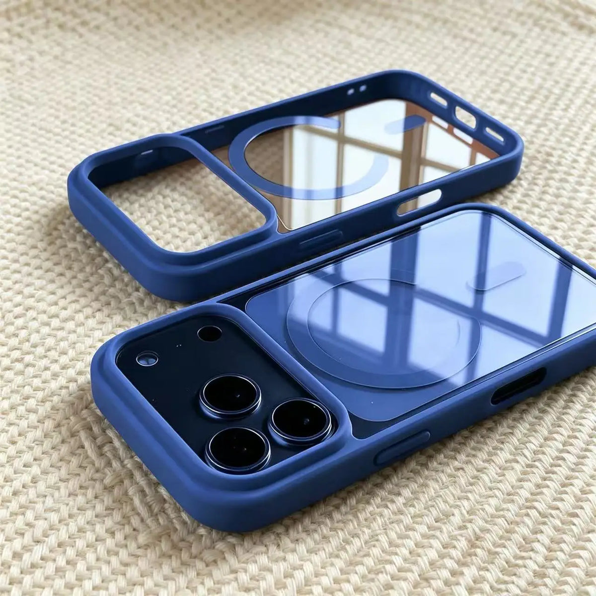 A blue transparent acrylic phone case with a clear back and a protective frame is shown on a beige textured surface.