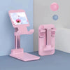 A pink adjustable desktop phone stand displaying a screen, next to a pink phone holder and floating spheres.