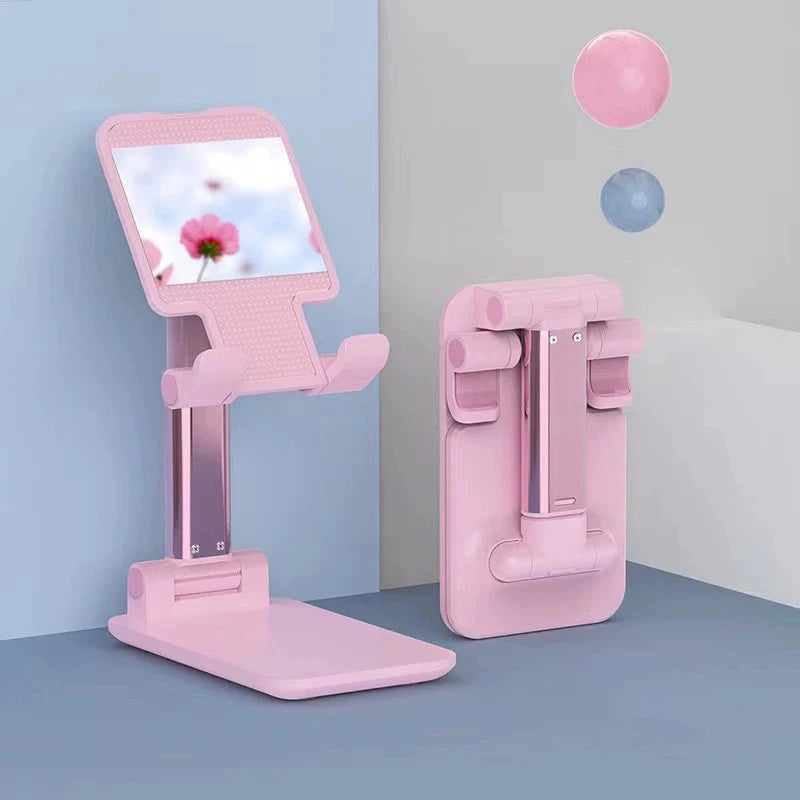 A pink adjustable desktop phone stand displaying a screen, next to a pink phone holder and floating spheres.