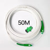 A coil of white single-mode fiber optic cable is shown, with a green connector visible.
