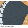 A set of black kraft envelopes is shown fanned out on a wooden surface.