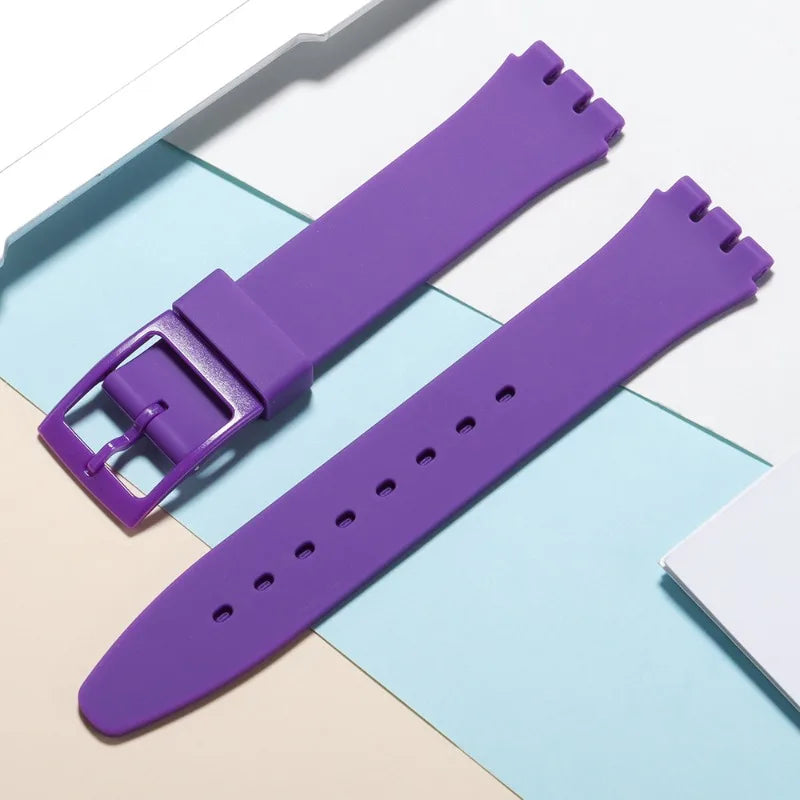 A purple silicone watch strap is shown next to its replacement tools on a light background.
