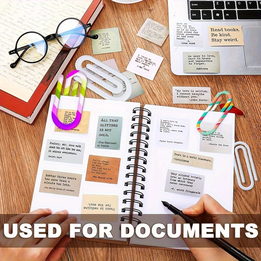 A close-up of a spiral notebook filled with various documents and jumbo acrylic paper clips on a wooden desk.