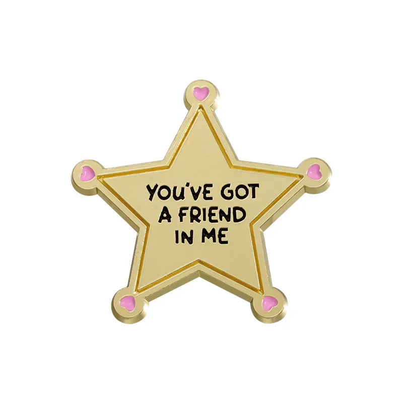 A gold star enamel pin with the text You've got a friend in me engraved on it.